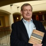 13a-Reynolds-WilliamMF04A_web Professor William L. Reynolds poses with the book he co-authored, ‘Injustice on Appeal: The United States Courts of Appeals in Crisis,’ at the University of Maryland Francis King Carey School of Law.