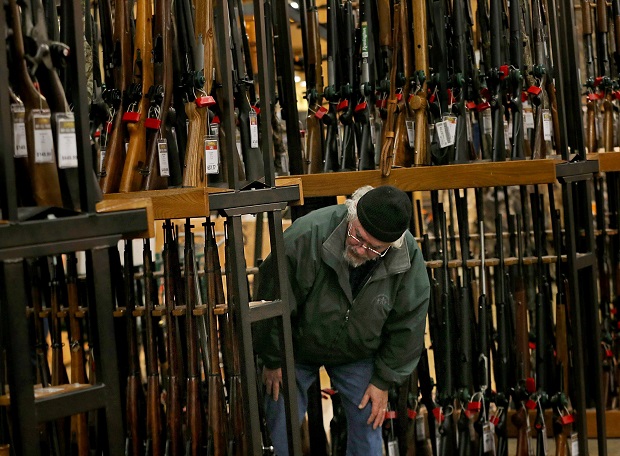 A man looks at the shotgun section of Cabela's while shopping on Black Friday in Hazelwood, Missouri. (Christian Gooden/St. Louis Post-Dispatch via AP)