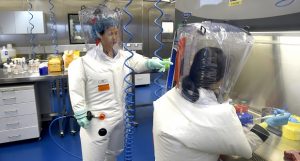 FILE - In this Thursday, Feb. 23, 2017 file photo, Shi Zhengli works with other researchers in a lab at the Wuhan Institute of Virology in Wuhan in central China's Hubei province. On Dec. 30, 2019, Shi, famous for having traced the SARS virus to a bat cave, was alerted to the new disease, according to an interview with Scientific American. By late January, when Chinese authorities walled off the city of Wuhan, where the disease was first diagnosed, it was too late to stop the spread. (Chinatopix via AP)