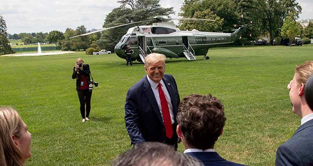 President Donald Trump speaks guests on the South Lawn before boarding Marine One on the South Lawn of the White House in Washington, Thursday, Aug. 6, 2020, for a short trip to Andrews Air Force Base, Md. and then on to Cleveland, Ohio. (AP Photo/Andrew Harnik)
