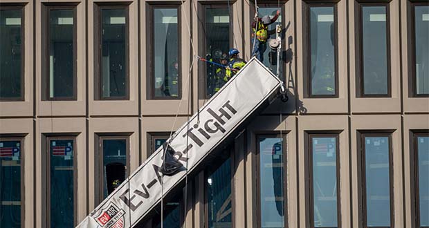 A worker stands on the end of a dangling scaffold as he waits to be rescued following an explosion at Baltimore Gas and Electric's offices, Wednesday, Dec. 23, 2020. Twenty-one of the victims were brought to area hospitals following the explosion with a partial roof collapse. The city’s fire department tweeted that at least nine of the victims were in critical condition, while another was in serious condition. (Jerry Jackson/The Baltimore Sun via AP)