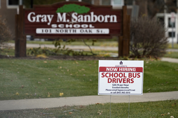 A hiring sign shows outside of Gray M. Sanborn Elementary School in Palatine, Ill., Thursday, Nov. 5, 2020. Illinois reports biggest spike in unemployment claims of all states. On Wednesday, Dec. 23, the number of Americans seeking unemployment benefits fell by 89,000 last week to a still-elevated 803,000, evidence that the job market remains under stress nine months after the coronavirus outbreak sent the U.S. economy into recession and caused millions of layoffs. (AP Photo/Nam Y. Huh)
