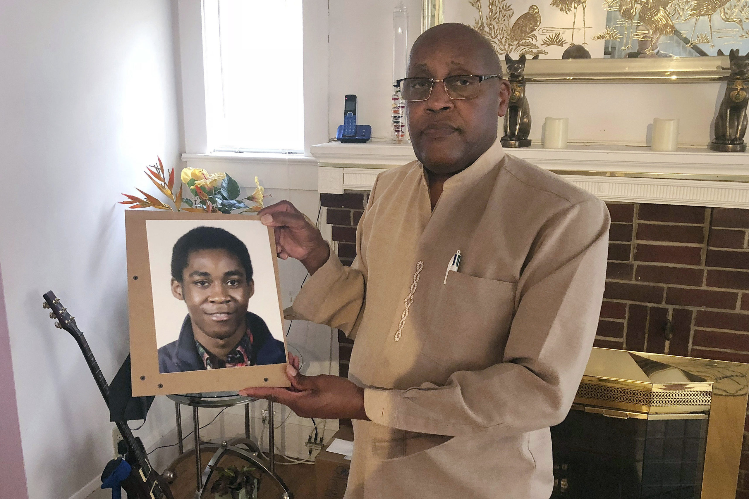 In this Sept. 5, 2018, file photo, Dia Khafra, father of Askia Khafra, holds a photo of his son in his Silver Spring home. Maryland's highest court on Jan. 28, 2022, upheld Daniel Beckwitt's conviction on a charge of involuntary manslaughter in the fiery death of Askia Khafra, who was helping him dig tunnels for a nuclear bunker under a home. (AP Photo/Michael Kunzelman, File)