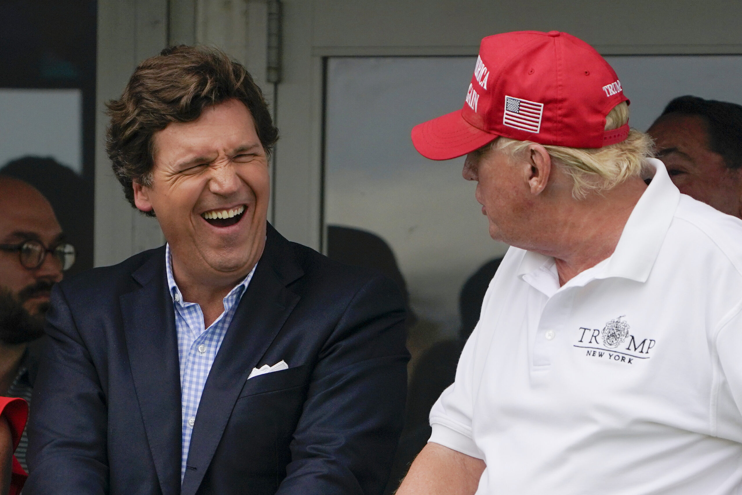 Tucker Carlson, left, and former President Donald Trump react during the final round of the Bedminster Invitational LIV Golf tournament in Bedminster, New Jersey, on July 31, 2022. (AP Photo/Seth Wenig, File)