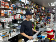 S. Shan works the cash register of his family's store, the Tien Rong Gift Shop, in the heavily Latino Ironbound section of Newark, N.J., U.S. September 16, 2025. (REUTERS/Nicholas P. Brown)