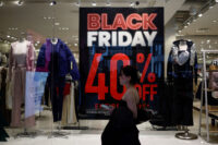 A shopper walks past an advertisement for Black Friday sales displayed in a store window at Pentagon City in Arlington, Virginia, November 27, 2024. (REUTERS file photo/Benoit Tessier)