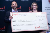 Ryan Eller (left), general manager of Live! Casino & Hotel Maryland, presents a check to Heather Geraldes, Executive Director of The Maryland Veterans Trust Foundation. (Ketia P./ LoveJustBecause LLC)