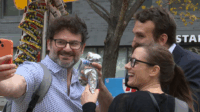 Furloughed IRS lawyer Isaac Stein, right at back, takes a photo with customers of his Shysters Dogs stand. (Kiliane Gateau/Capital News Service)