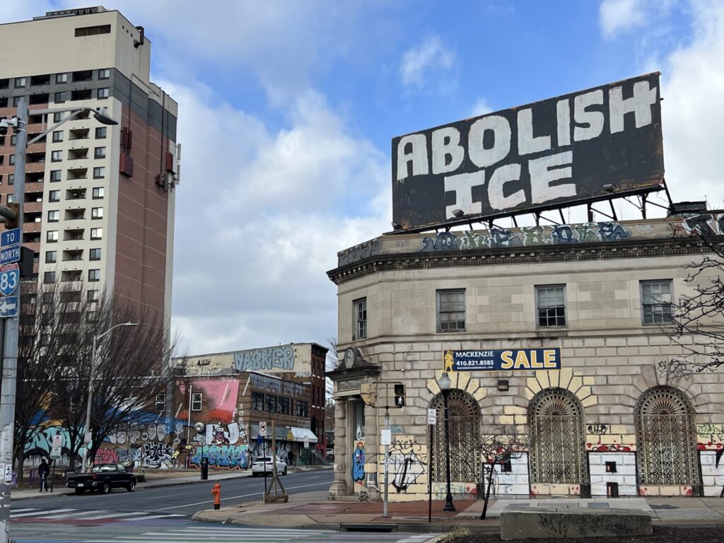 Graffiti on a billboard in Baltimore City calls for the abolition of ICE. (Ian Round/The Daily Record)