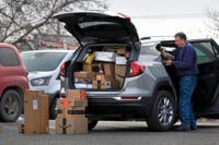 A man loads packages for delivery in Bemidji, Minnesota, in 2023. (Dan Koeck/For The Washington Post)