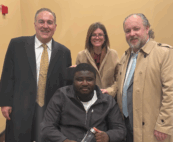 Godlove Djapa, center, poses for a photo with his attorneys after a jury awarded him more than $71 million. His attorneys, from left, are Briggs Bedigian, Lauren Geisser and Jon Stefanuca. (Submitted photo)