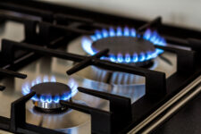 Natural gas is seen burning on a kitchen gas stove in the dark. (Depositphotos)