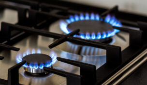 Natural gas is seen burning on a kitchen gas stove in the dark. (Depositphotos)