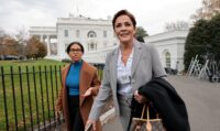 A reporter trails United States Agency for Global Media's (USAGM) Kari Lake as she walks on the driveway outside the West Wing of the White House in Washington, on Nov. 21, 2025. (REUTERS/Jonathan Ernst/File Photo)
