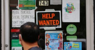 A pedestrian passes a "Help Wanted" sign in the door of a hardware store in Cambridge, Massachusetts, on July 8, 2022. (REUTERS/Brian Snyder/File Photo)