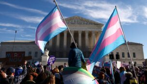Demonstrators carry a transgender flags outside the U.S. Supreme Court, on the day justices were expected to hear oral arguments in two cases concerning efforts to enforce Republican-backed state laws banning transgender athletes from female sports teams at public schools, in Washington, D.C., on January 13, 2026. (REUTERS/Kevin Lamarque)