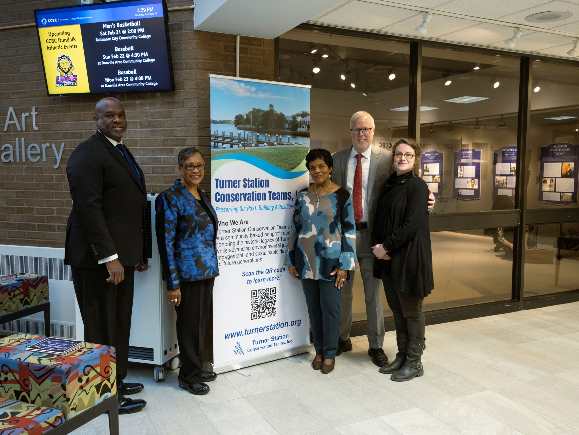 The reception featured a banner with information on Turner Station Conservation Teams Inc., led by President Gloria Nelson, second from left, and Board Member Edythe Brooks, third from left. They pose with, from left, CCBC Dundalk Campus Director Eric Washington; CCBC School of Arts and Communication Dean R. Michael Walsh; and CCBC Art Gallery Coordinator Nicole Buckingham Kern. (Eye See You Photography LLC/Zeinab Shafiee/Samantha Trionfo)