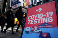People walk past a COVID-19 testing sign during the coronavirus disease (COVID-19) pandemic in the Manhattan borough of New York City, New York, January 20, 2022. (REUTERS/Carlo Allegri/File Photo)