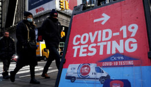 People walk past a COVID-19 testing sign during the coronavirus disease (COVID-19) pandemic in the Manhattan borough of New York City, New York, January 20, 2022. (REUTERS/Carlo Allegri/File Photo)