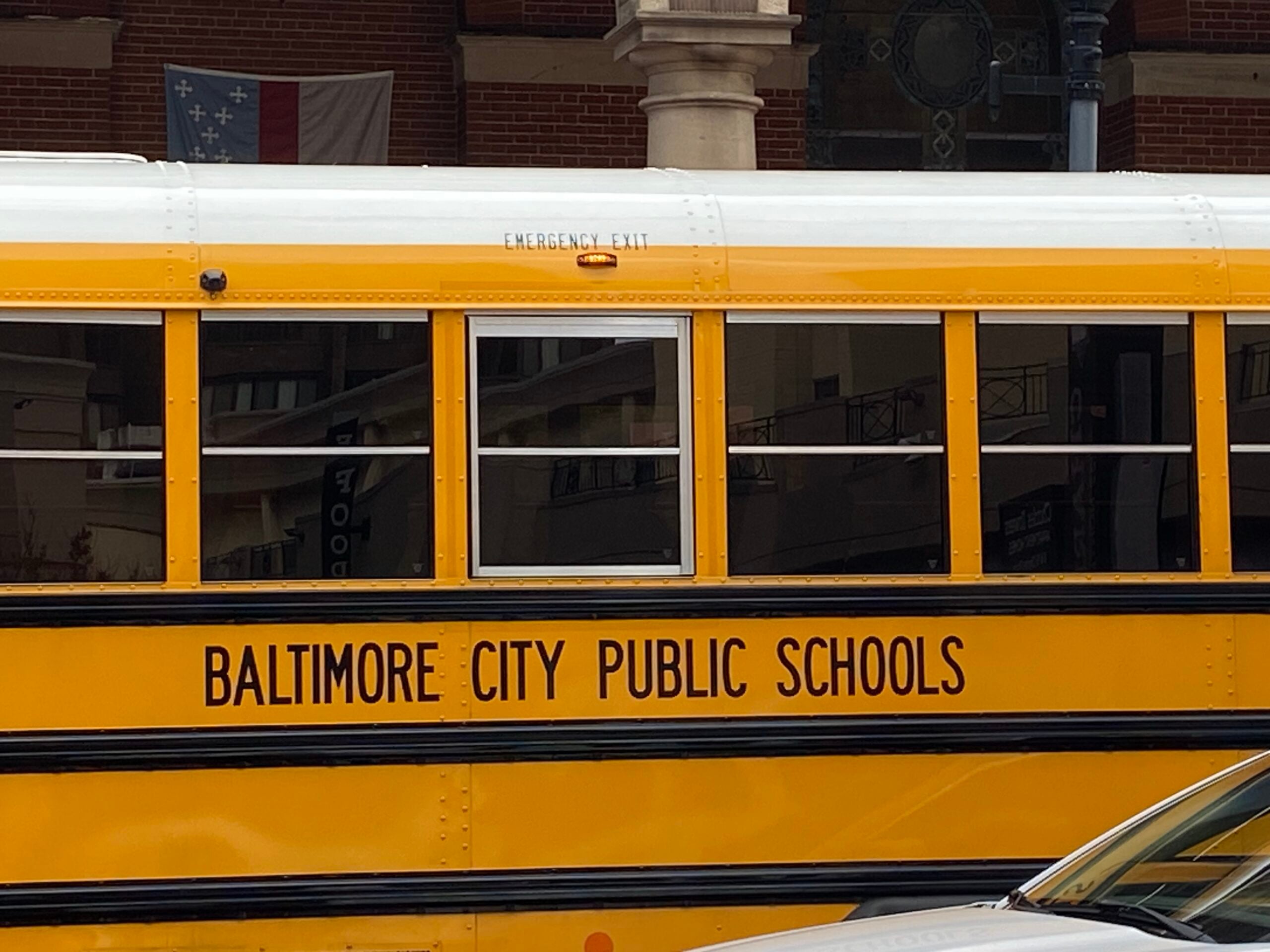 A Baltimore City Public Schools bus stops on Charles Street downtown on May 14, 2026. The school system only uses a few yellow school buses, while many students rely on the city's public transit. (Kendyl Kearly/The Daily Record)
