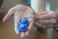Deanna Bracken, special liaison for the Baltimore Police Department's Community Partnerships Unit, holds a tactile keychain given to people who register on a recently launched database for neurodivergent people. The keychain is intended to help officers identify people who are neurodivergent during interactions and find their emergency contact information using a unique identifier number.
