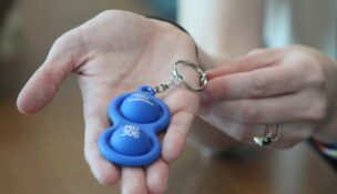 Deanna Bracken, special liaison for the Baltimore Police Department's Community Partnerships Unit, holds a tactile keychain given to people who register on a recently launched database for neurodivergent people. The keychain is intended to help officers identify people who are neurodivergent during interactions and find their emergency contact information using a unique identifier number.