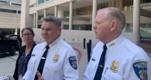 Baltimore Police Commissioner Richard Worley, flanked by Compliance Division Chief Shannon Sullivan and Deputy Commissioner Brian Nadeau, speaks with reporters outside of the Edward A. Garmatz U.S. Courthouse following a quarterly hearing on the status of the department's consent decree.