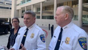 Baltimore Police Commissioner Richard Worley, flanked by Compliance Division Chief Shannon Sullivan and Deputy Commissioner Brian Nadeau, speaks with reporters outside of the Edward A. Garmatz U.S. Courthouse following a quarterly hearing on the status of the department's consent decree.
