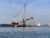 Two years after the Francis Scott Key Bridge collapsed, the Weeks 533 crane drives a pile beneath the Patapsco River on the site of a new bridge. (Dan Belson/The Daily Record)
