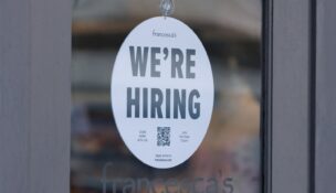 A "we're hiring" sign is displayed on the door of a local business, after U.S. employment growth slowed more than expected in July, in Encinitas, California, on Aug. 1, 2025. (REUTERS/Mike Blake)