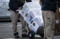 Workers load boxes into a truck at the Eisenhower Executive Office Building in 2021. (Jabin Botsford/The Washington Post)