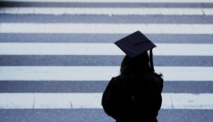 A graduating student waits to cross the street in Cambridge, Massachusetts, on June 7, 2019. (REUTERS/Brian Snyder/File Photo)
