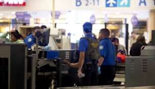 An Immigration and Customs Enforcement (ICE) agent assists Transportation Security Administration (TSA) officers as passengers are screened at a checkpoint at Luis Munoz Marin International Airport in Carolina, Puerto Rico, on March 27, 2026. (REUTERS/Ricardo Arduengo)