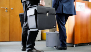 People with briefcases come out of a boardroom in this file photo dated July 29, 2020. (REUTERS file photo/Axel Schmidt)