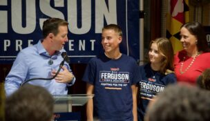 Senate President Bill Ferguson (D-Baltimore City) is joined on stage by his wife, Lea, and their children, Caleb and Cora, at an election night victory party Tuesday, after Ferguson survived one of his biggest political challenges in years. (Photo by Christine Condon/Maryland Matters)
