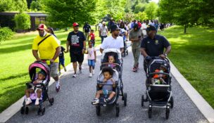 Baltimore Mayor Brandon M. Scott, center, and City Council member Paris Gray, right, lead a stroller walk Thursday at Cylburn Arboretum in Baltimore. (Photo by Pete Kiehart for The Washington Post)