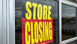 Retail store is going out of business with a large banner displaying store closing sale by Depositphotos