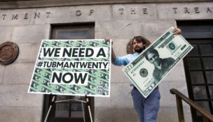 Capitol Hill staff member places signs before a news conference by House Majority Leader Steny Hoyer (D-Md.) on Treasury Secretary Steve Mnuchin's decision to indefinitely delay putting famous abolitionist Harriet Tubman on the new $20 bill, on the steps of the Treasury Department in Washington, D.C, June 27, 2019. (REUTERS/Yuri Gripas/File Photo)