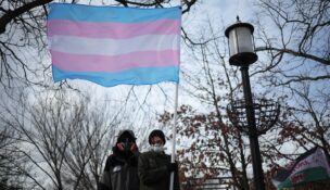 A protester displays a transgender flag at Meridian Hill Park on the inauguration day of Donald Trump's second presidential term in Washington on Jan. 20, 2025. (REUTERS/Marko Djurica)