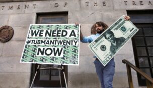 Capitol Hill staff member places signs before a news conference by House Majority Leader Steny Hoyer (D-MD) on Treasury Secretary Steve Mnuchin's decision to indefinitely delay putting famous abolitionist Harriet Tubman on the new $20 bill, on the steps of the Treasury Department in Washington on June 27, 2019. (REUTERS/Yuri Gripas/File Photo)