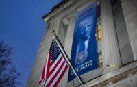A banner depicting President Donald Trump is put up on the Department of Justice building in Washington on Feb. 20, 2026. (REUTERS/Ken Cedeno/File Photo)